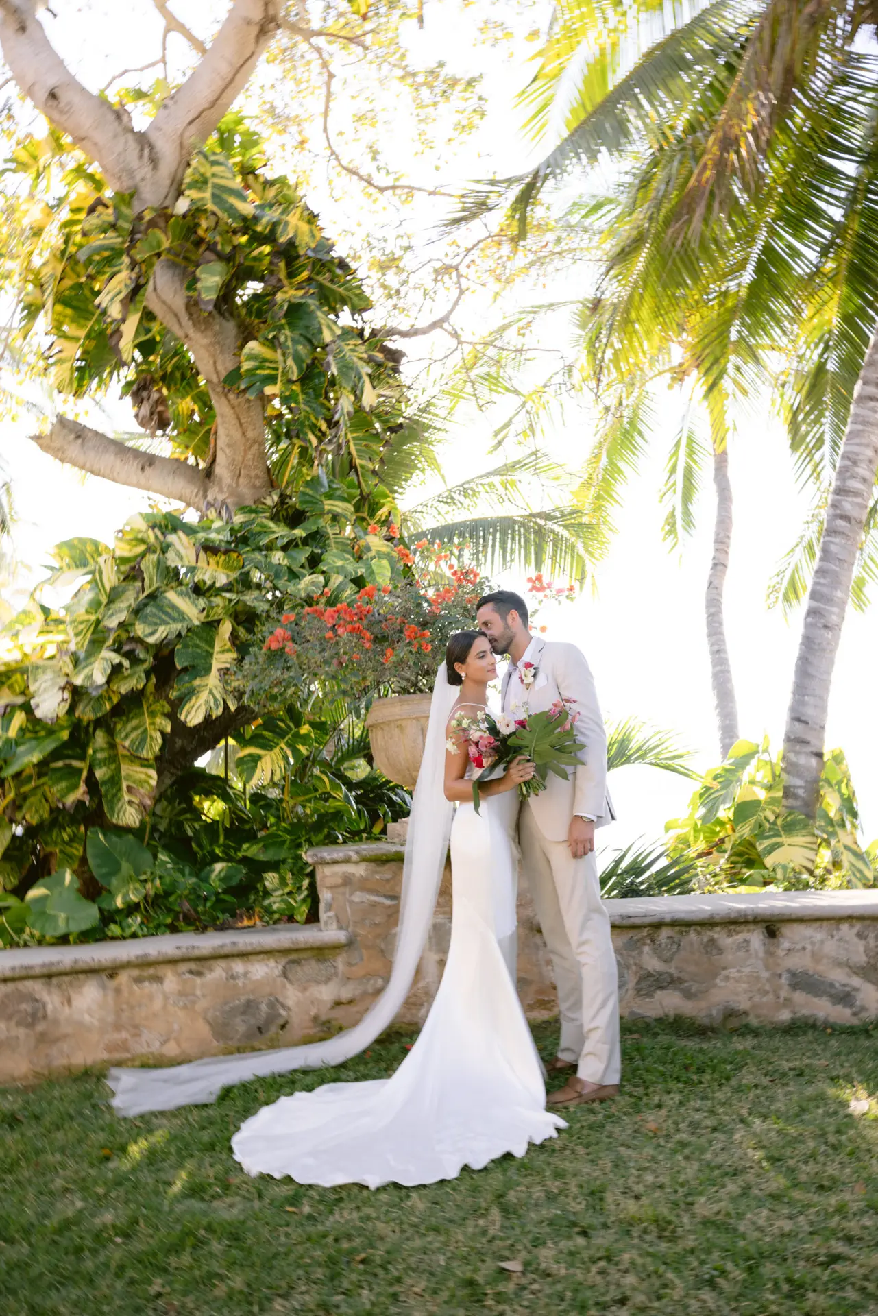 Couple kissing in tropical garden setting. photo taken by Ximena Zermeño Global Luxury Destination Wedding Photographer, ximenazermeno.com