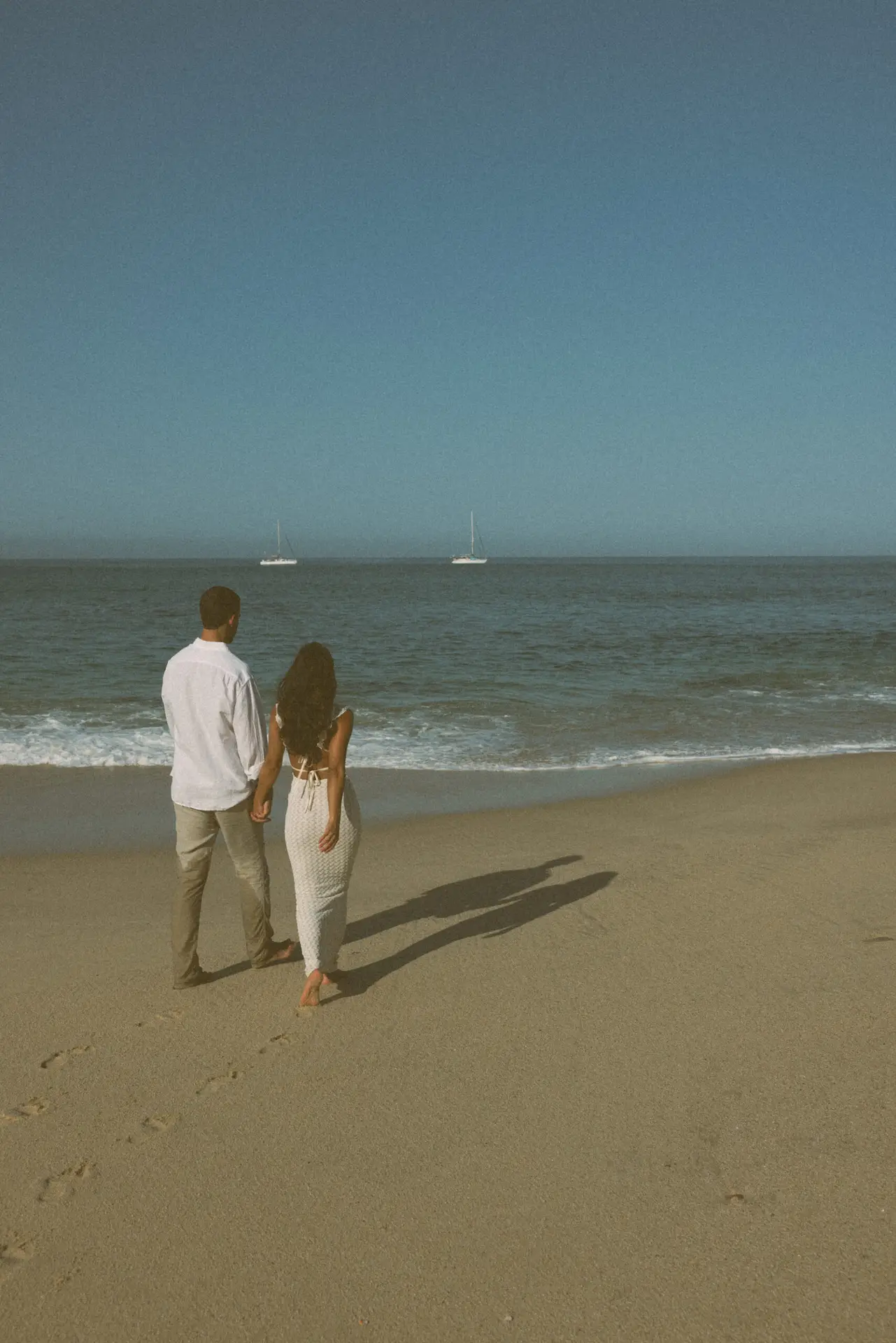 couple walking by the sea photo taken by Ximena Zermeño Global Luxury Destination Wedding Photographer, ximenazermeno.com